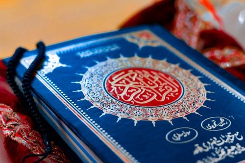 Photograph of a printed Mushaf with a blue cover used for meaning study